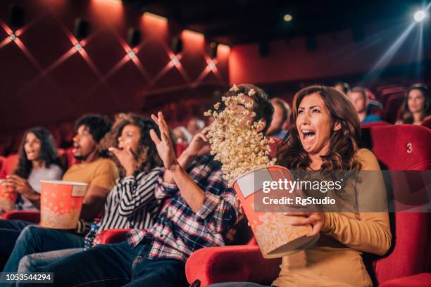 doodsbang vrienden morsen popcorn in bioscoop - scary movie stockfoto's en -beelden