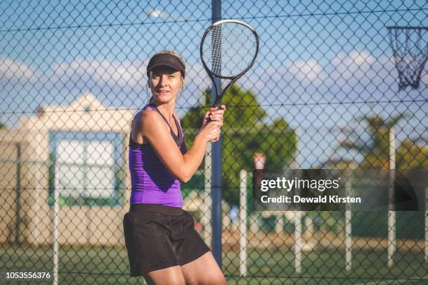 close up image of a female tennis player playing tennis on a court in bright sunlight - tennis raquet close up photos et images de collection