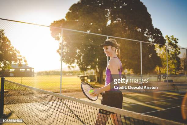 close up portrait of a female tennis player on a tennis court with beautiful warm back light sunset. - tennis raquet close up photos et images de collection