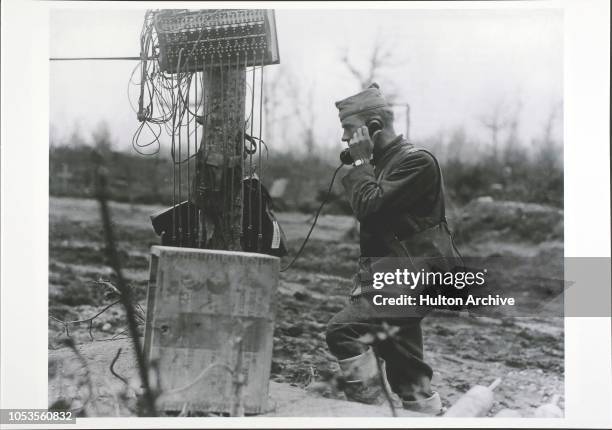 Soldier Call, Second Llieutenant Edward E French, of the 52nd Telegraph Battalion, stands by a switchboard speaking on the telephone at a crossroads...