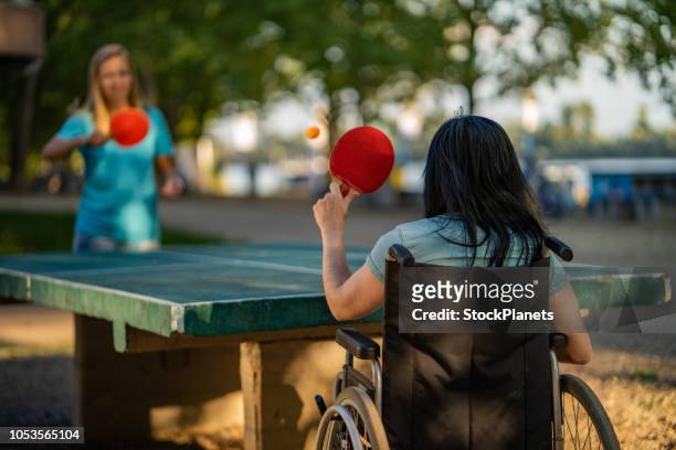 back view women on a wheelchair playing table tennis - sister imagens e fotografias de stock