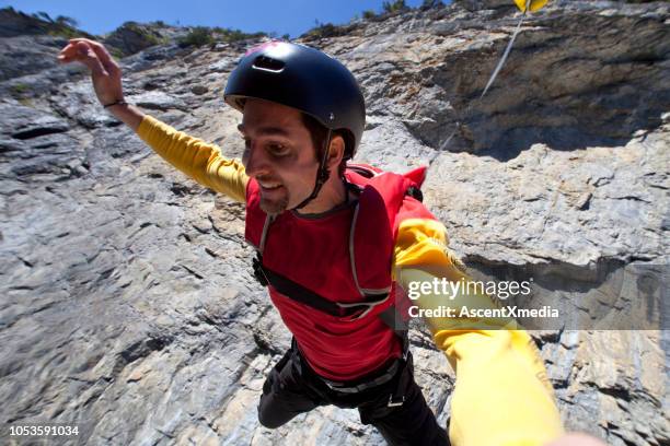 point of view as base jumper jumps off cliff - cliff jumping stock pictures, royalty-free photos & images