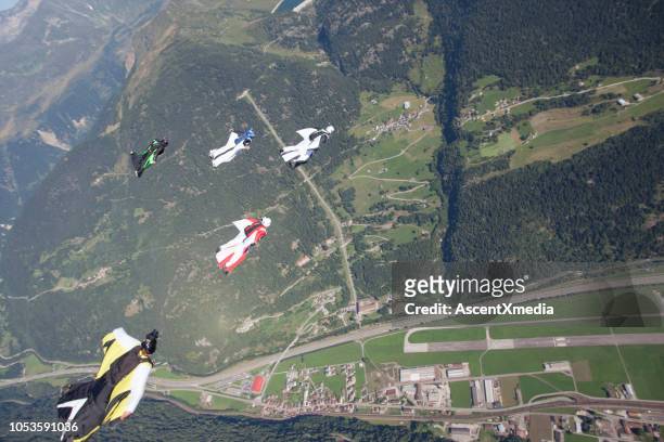 five wingsuiters fly in formation - wing suit stock pictures, royalty-free photos & images