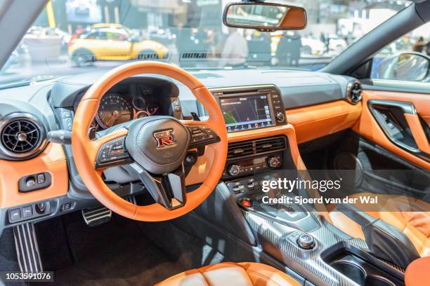 Interior on a Nissan GT-R high performance sports car with brown leather trim and information displays on the dashboard on display at Brussels Expo...