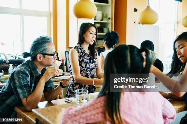 family gathered together in kitchen eating lunch - indian couple at home stock-fotos und bilder