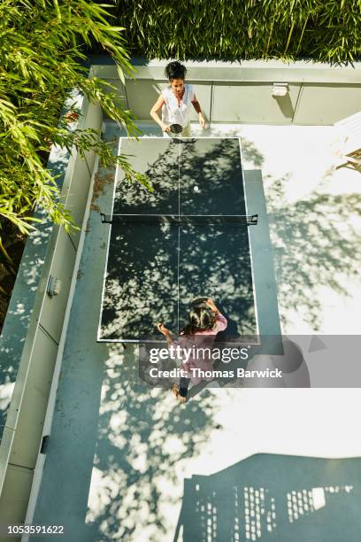 overhead view of young girl and aunt playing table tennis in backyard - women's table tennis stock-fotos und bilder