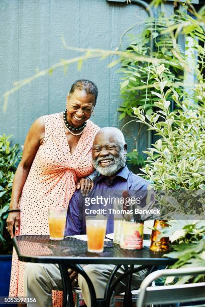 Portrait of laughing senior couple at outdoor cafe on summer afternoon