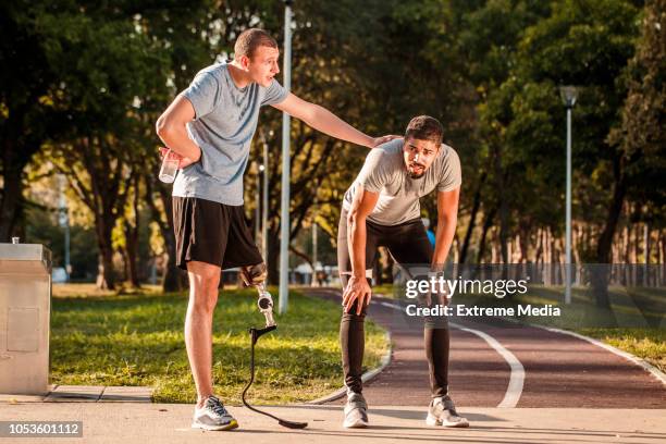 amigos cansados en la pista de atletismo - hand on knee fotografías e imágenes de stock