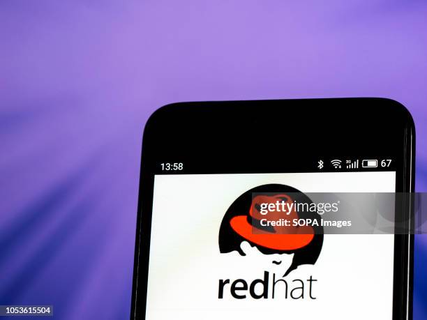 In this photo illustration, the Red Hat Software company logo seen displayed on a smartphone. Red Hat, Inc. Is an American multinational software...