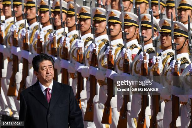 Japan's Prime Minister Shinzo Abe reviews a military honour guard with Chinese Premier Li Keqiang during a welcome ceremony outside the Great Hall of...