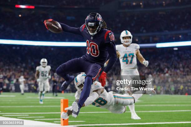 DeAndre Hopkins of the Houston Texans catches a pass and runs for a touchdown in the fourth quarter defended by Bobby McCain of the Miami Dolphins at...