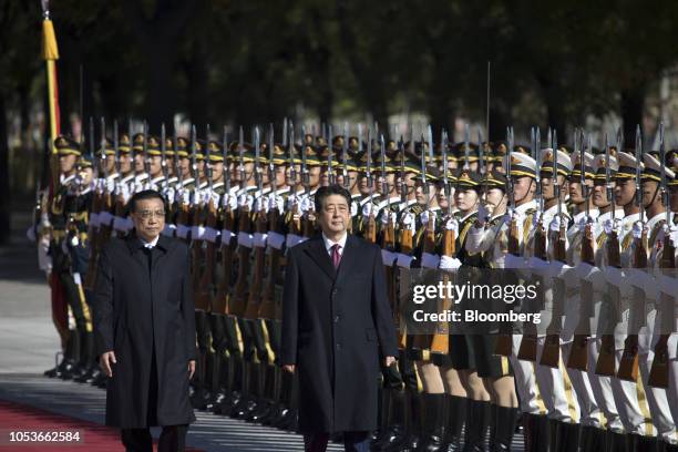 Shinzo Abe, Japan's prime minister, center, and Li Keqiang, China's premier, observe a guard of honor during a welcome ceremony at the Great Hall of...