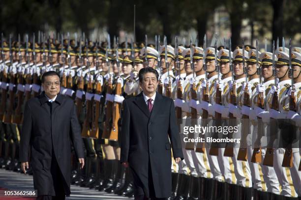 Shinzo Abe, Japan's prime minister, center, and Li Keqiang, China's premier, observe a guard of honor during a welcome ceremony at the Great Hall of...