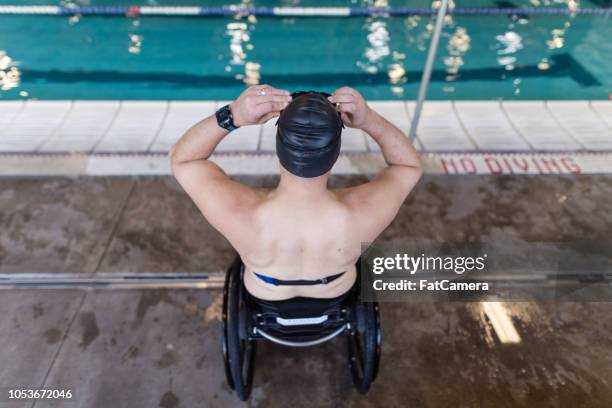 adaptive athlete prepares to swim in a pool - paraplégico imagens e fotografias de stock