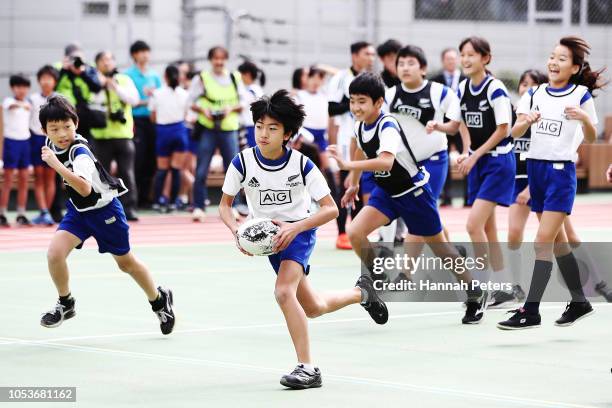 Children take part in an All Blacks coaching clinic during a New Zealand All Blacks visit to the Shiba Elementary School on October 26, 2018 in...