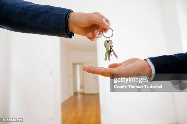 Posed scene on the topic of handing over an apartment. A estate agent hands flat keys in an empty apartment on October 25, 2018 in Berlin, Germany.