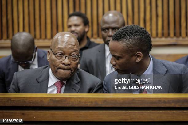 Former President of South Africa, Jacob Zuma speaks to his son Duduzane Zuma at the Randburg Magistrates Court on October 26 in Johannesburg. -...