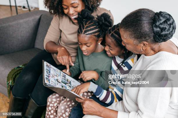 grandmother, daughter and grandkids looking at photo album - tradition stock pictures, royalty-free photos & images