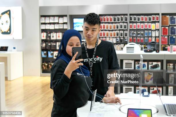 Apple store staffs check the new iPhones XS at the Apple store during the launch of the iPhone XS on October 26, 2018 in Kuala Lumpur, Malaysia. The...