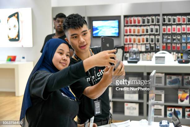 Apple store staffs check the new iPhones XS at the Apple store during the launch of the iPhone XS on October 26, 2018 in Kuala Lumpur, Malaysia. The...