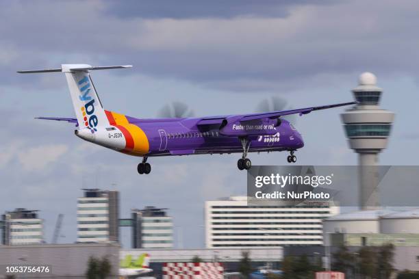 Flybe aircraft landing in Amsterdam Schiphol Airport in The Netherlands. The aircraft is a turboprop De Havilland Canada DHC-8-400 with registration...