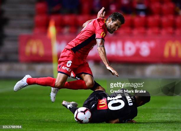 Vince Lia of Adelaide United fouls Ronald Vargas of the Newcastle Jets during the round two A-League match between Adelaide United and the Newcastle...
