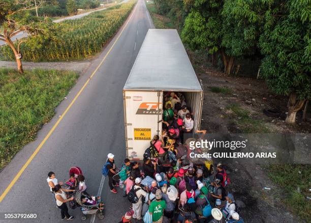 Honduran migrants taking part in a caravan heading to the US, get on a truck, near Pijijiapan, southern Mexico on October 26, 2018. - The Pentagon is...