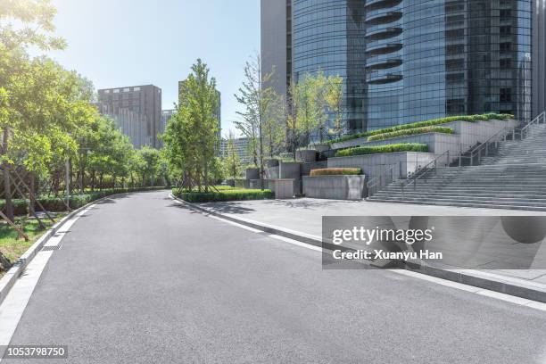 park pedestrian walkway toward modern skyscrapers - parque comercial imagens e fotografias de stock