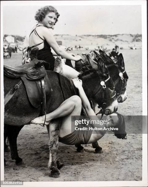Girl falls off her mount when taking donkey rides on the sand at Porthcawl, South Wales.