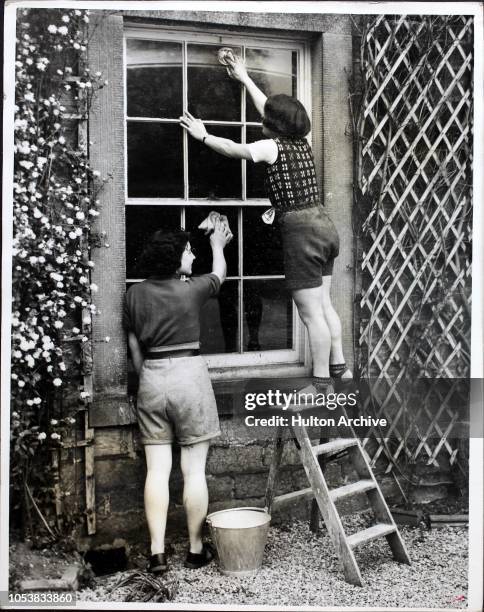 Girls of the Sheffield Youth Hostel Association cleaning the windows of the new hostel, Leam Hall, which is situated between Hathersage and Eyam, for...