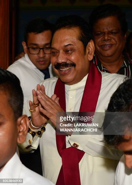 Sri Lanka's former president and new prime minister Mahinda Rajapaksa leaves a temple where he offered prayers after having been sworn in as prime...