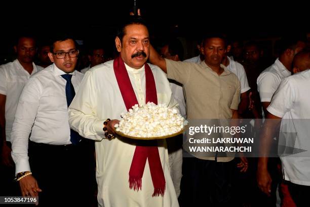 Sri Lanka's former president and new prime minister Mahinda Rajapaksa arrives at a temple after having been sworn in as prime minister in Colombo on...