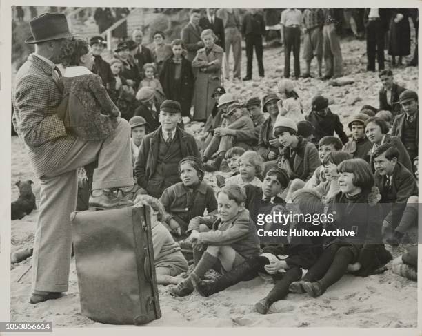 Holding His Audience, A ventriloquist on the sands at Porthcawl holds the kiddies spellbound while giving his performance - their expressions being...