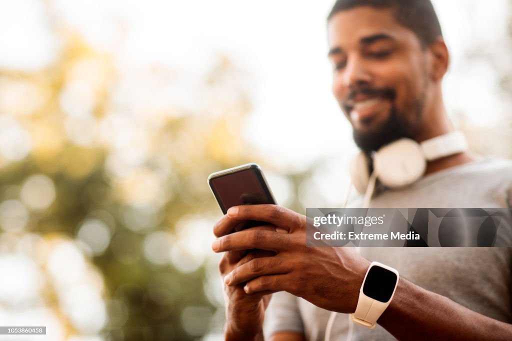 Athlète masculin à l’aide de téléphone portable