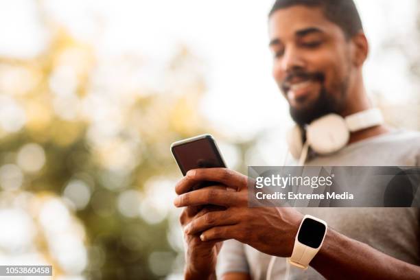 male athlete using mobile phone - black influencer stock pictures, royalty-free photos & images