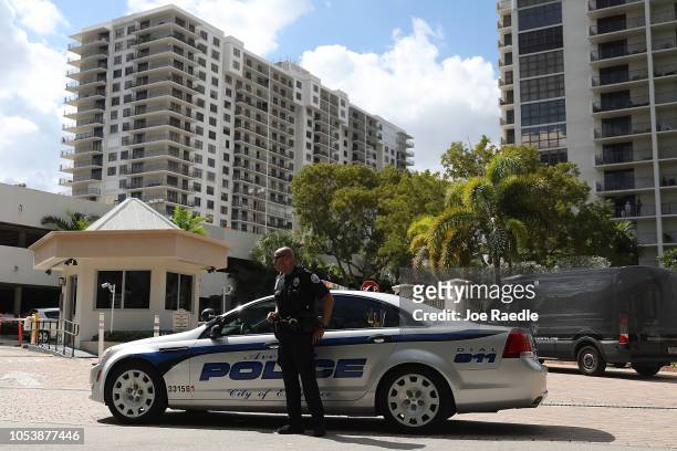An Aventura City police officer stands across the street from the condo building that has a possible connection to alleged bomber Cesar Sayoc and his...