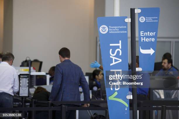 Transportation Security Administration PreCheck sign is displayed as travelers carry baggage through a security checkpoint at Los Angeles...
