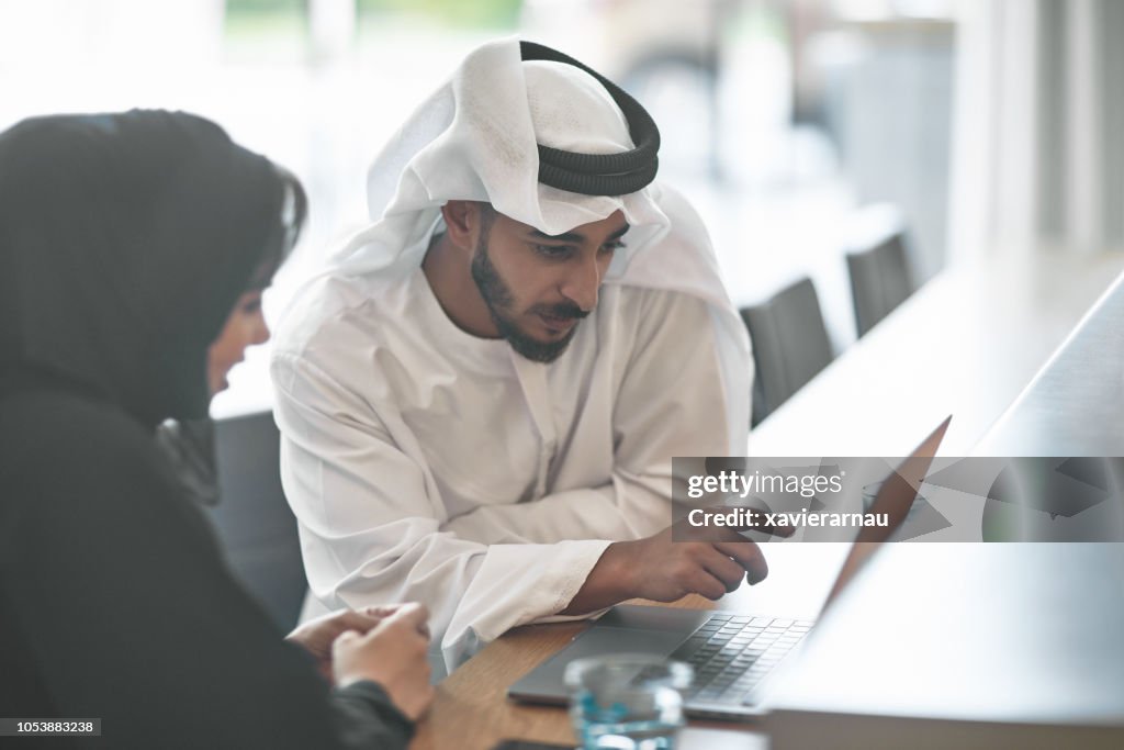 Emirati entrepreneurs discussing over laptop