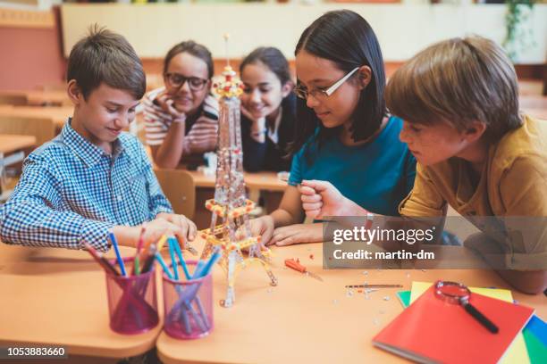 school children assembling metal construction kit in the classroom - public school building stock pictures, royalty-free photos & images