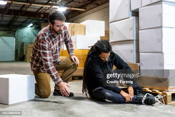 a warehouse worker hurt after falling beside a pallet - injured at work stock pictures, royalty-free photos & images