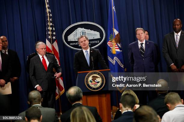 Director Christopher Wray, accompanied by officials including Attorney General Jeff Sessions, speaks at a press conference about the apprehension of...