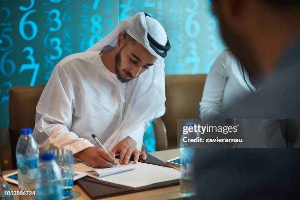 emiraten zakenman maken van aantekeningen in bestuurskamer - people from oman stockfoto's en -beelden