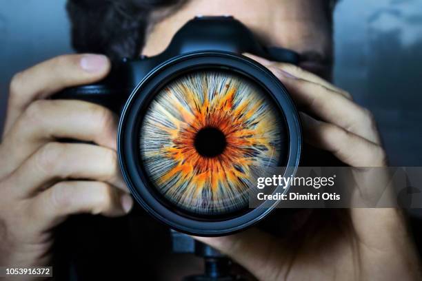 man holding camera with iris as lens - lens eye stock-fotos und bilder