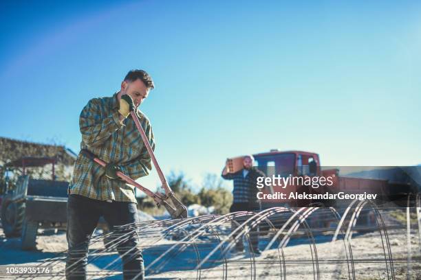 hipster construction worker cutting steel bars - bolt cutter stock pictures, royalty-free photos & images