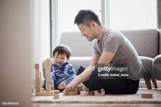 father and son playing with building blocks together - single father stock pictures, royalty-free photos & images