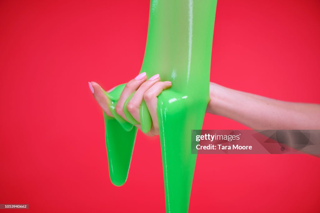 Hand with slime on red background