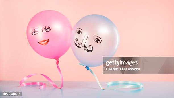 pink and blue helium balloons with smiling faces floating - stereotipo foto e immagini stock
