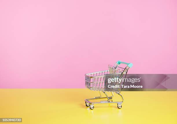 toy shopping trolley with pink  and yellow background - cart fotografías e imágenes de stock