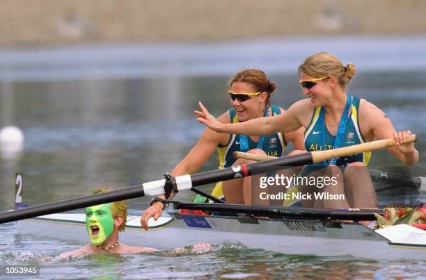 Luke Taylor swims out to congrulate sister Rachel Taylor and Kate Slatter of Australia after they win silver in the Women's Coxless Pair Rowing Final...