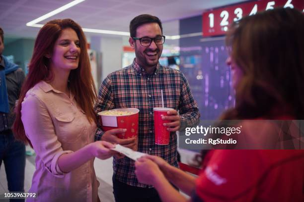 smiling couple having movie tickets checked - movie catering stock pictures, royalty-free photos & images